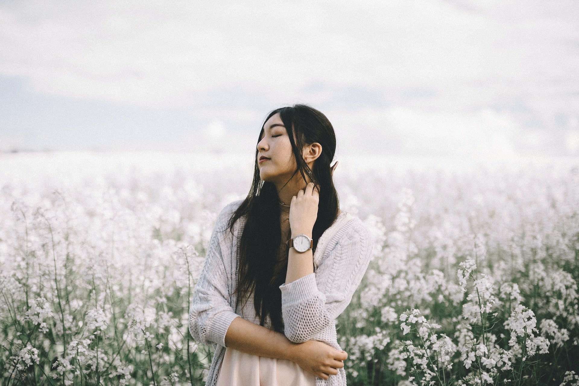 lady standing in a field of flowers wearing a wristwatch